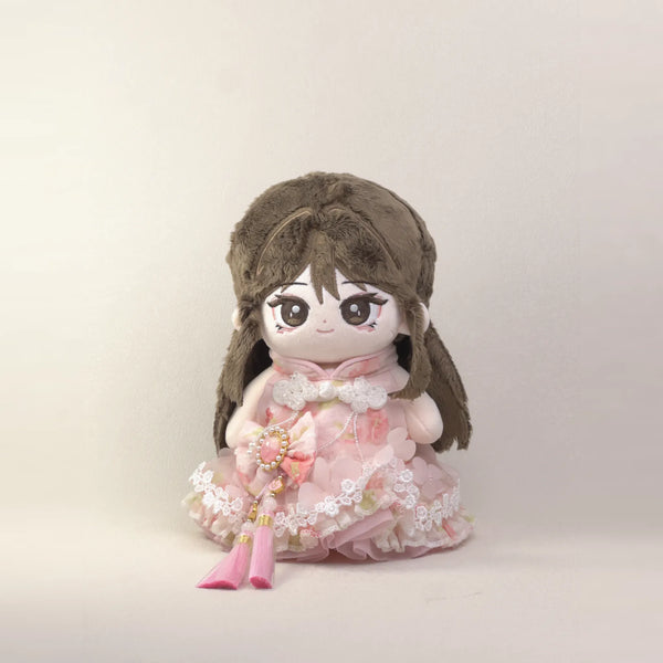 Cotton doll wearing the Cherry Tassel outfit: blush floral dress with knot buttons, lace trim, pearl cameo bow and pink tassel, front view
