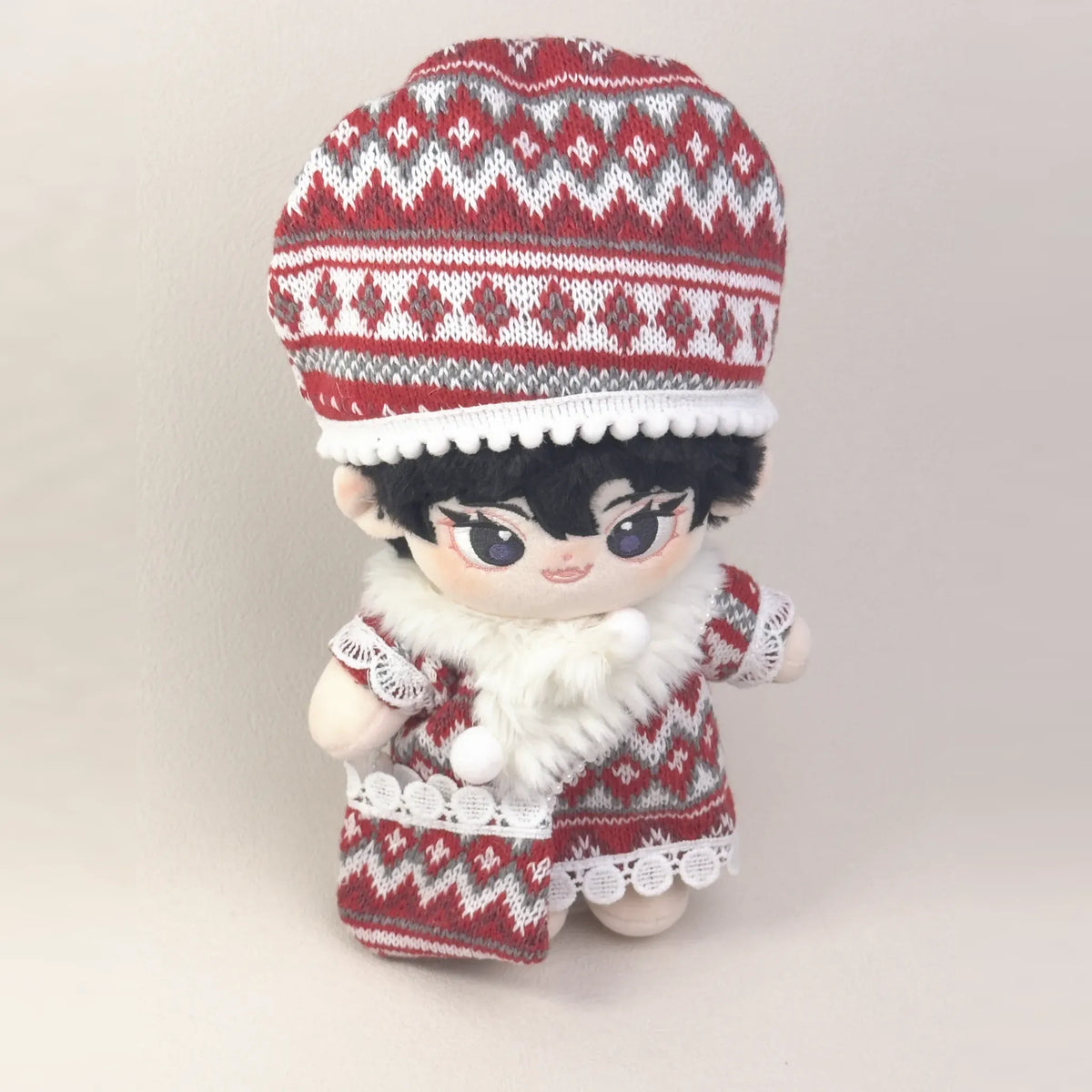 Cotton doll wearing the Fireside Knit outfit: red fair-isle knit dress, slouchy knit hat, white faux-fur scarf and knit bag, view from above