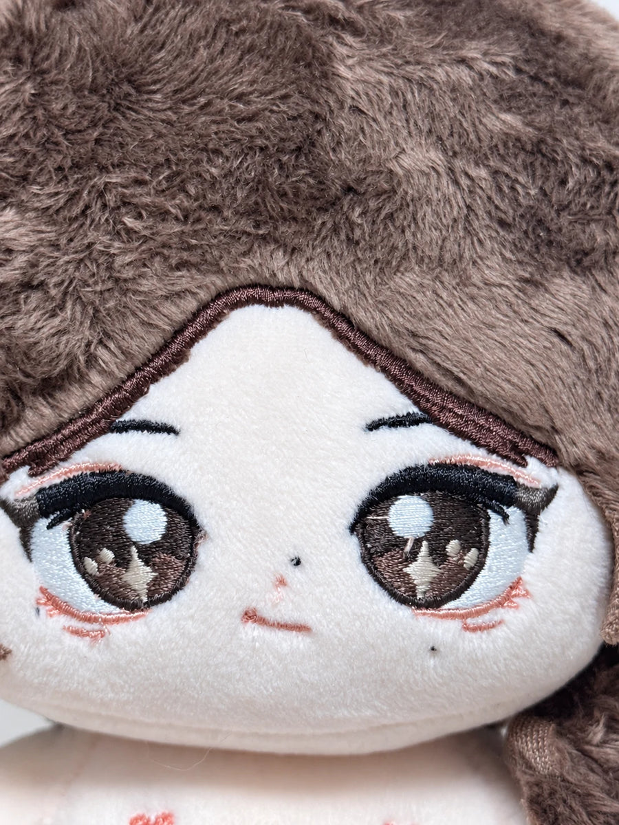 Close-up of the embroidered eyes and face on Rain's custom cotton doll