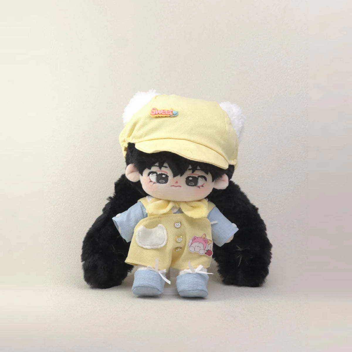 Cotton doll wearing the Sunny Kitten outfit: yellow overalls, light blue shirt, yellow neck bow, cat-ear cap and blue shoes, front view