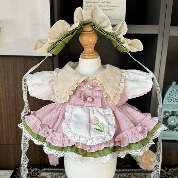 Tulip Meadow Apron Dress & Bonnet for cotton dolls: dusty pink dress, cream collar, tulip-embroidered lace apron, cream bonnet, front view